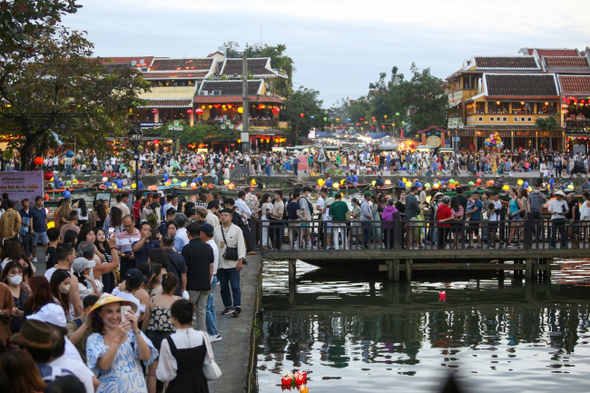 cultural heritage, full moon of january, hoi an ancient town, intangible and intangible culture, lunar new year, tourists walk around hoi an ancient town, waiting in long queues to drop flower lanterns on the tet holiday