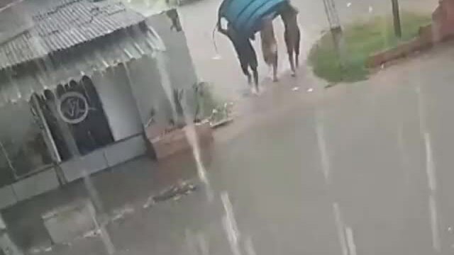 Thanh niên bơi thuyền giữa phố khi mưa