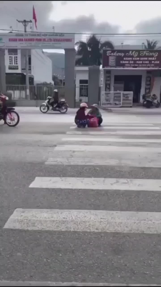 Hai người phụ nữ vô tư trò chuyện giữa đường
